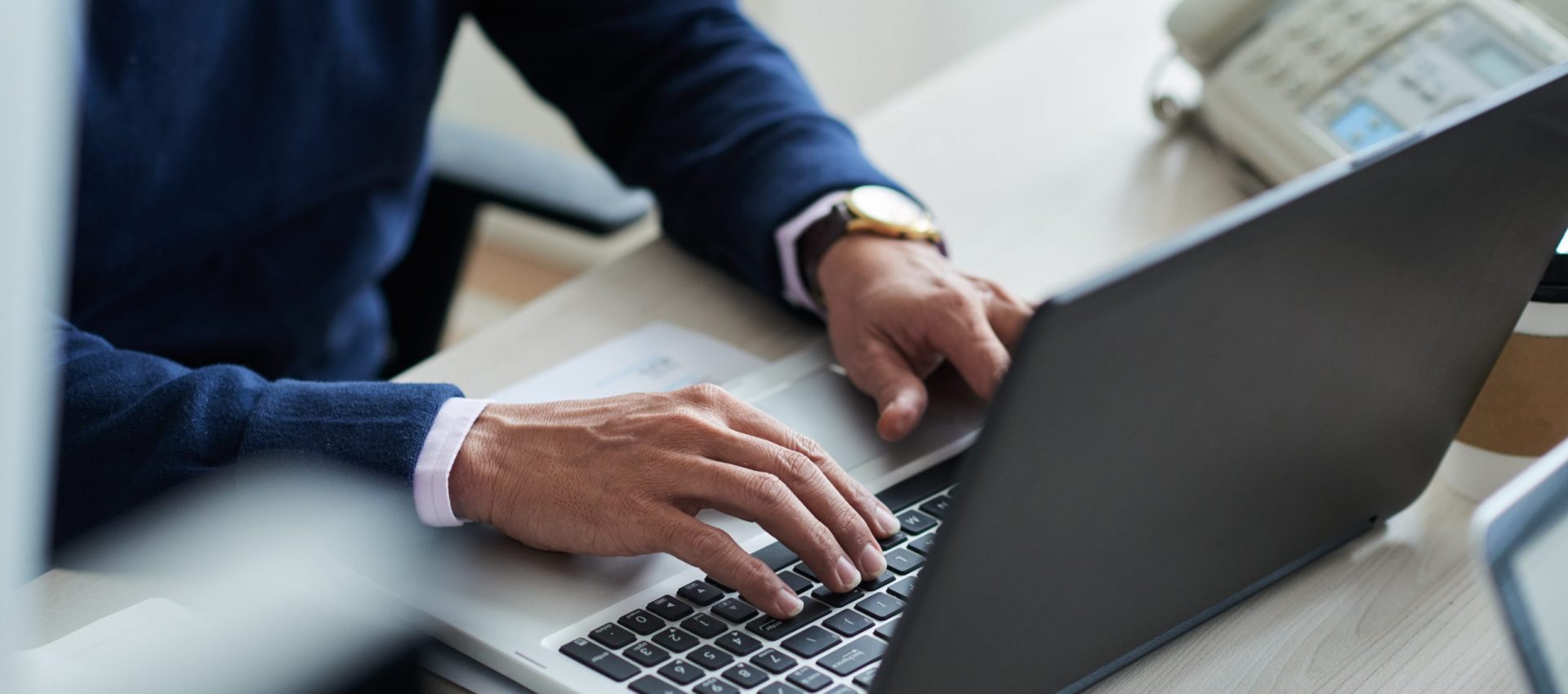 Close-up image of businessman typing on laptop at his workplace